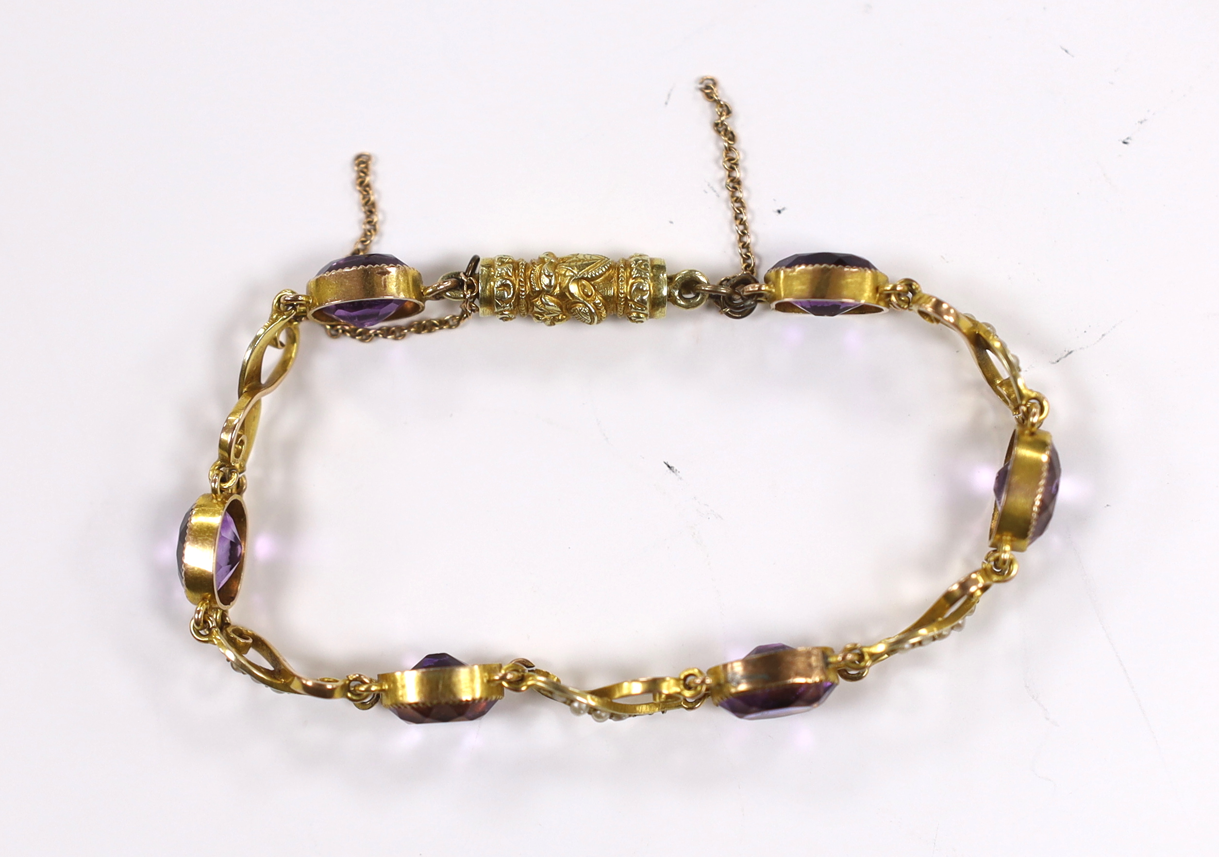 An early 20th century 9ct, amethyst and seed pearl cluster set bracelet, with carved barrel shaped clasp, approx. 16cm gross weight 8.4 grams.